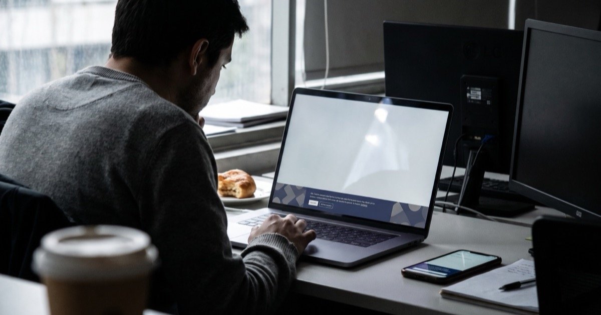 Persona revisando en su notebook un sitio web con un aviso de cookies en la parte inferior de la pantalla